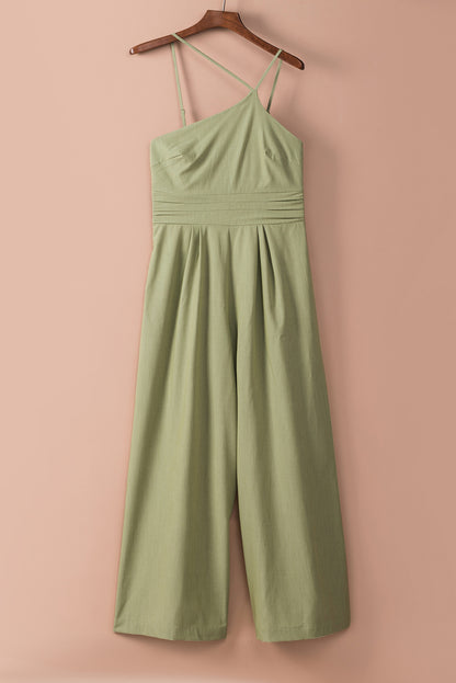 Groene asymmetrische jumpsuit met dunne bandjes, één schouder en wijde pijpen