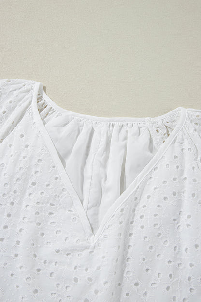 Witte blouse met V-hals, pofmouwen en geborduurde oogjes