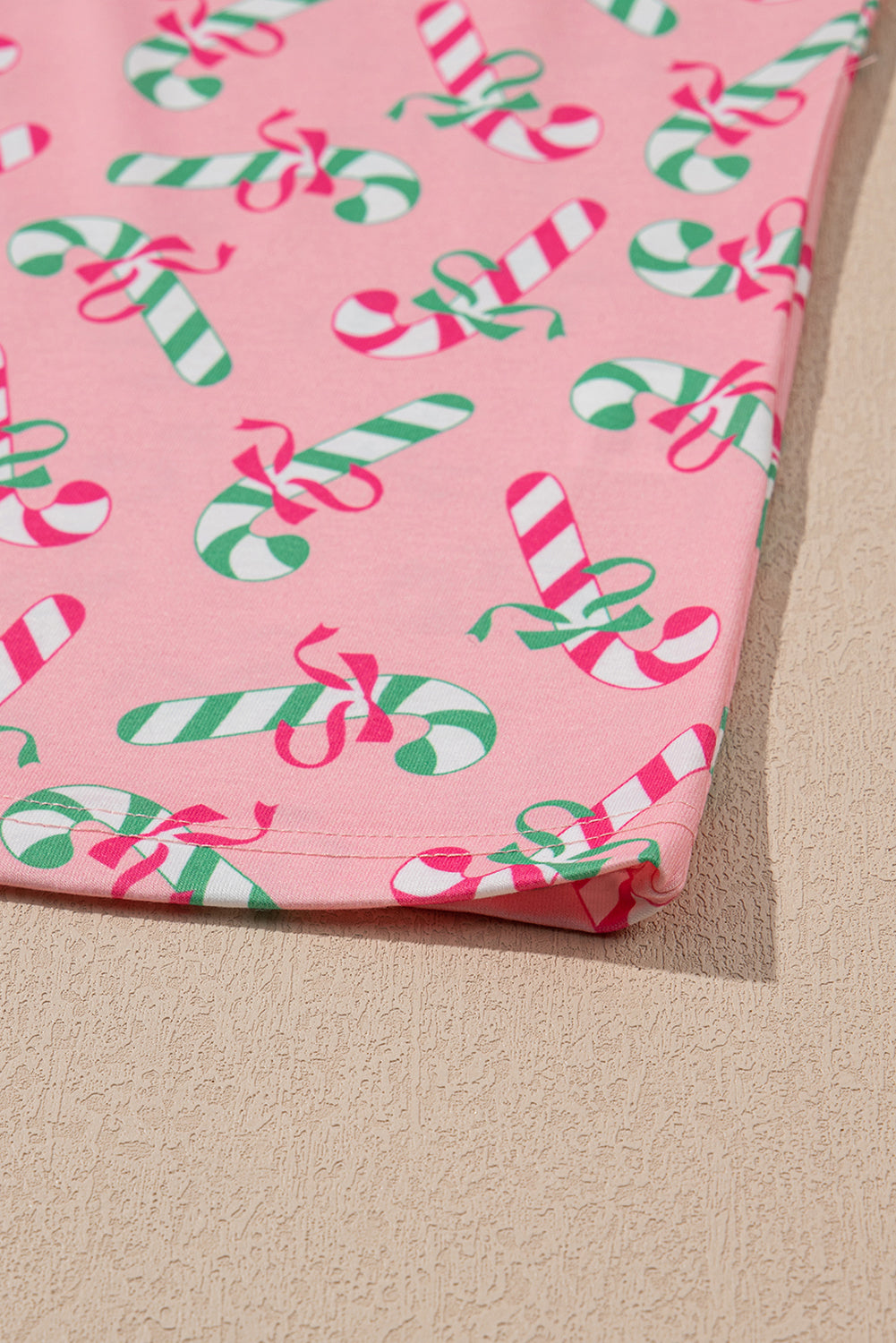 Roze kerstpyjamaset met knoop en zakmotief in zuurstokprint