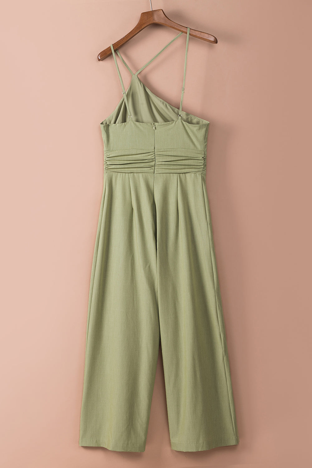 Groene asymmetrische jumpsuit met dunne bandjes, één schouder en wijde pijpen