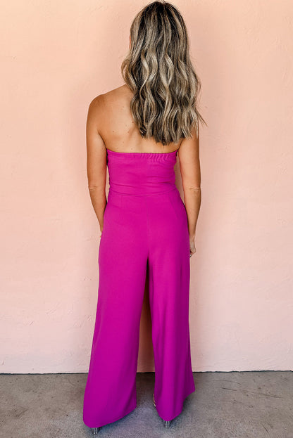 Felroze strapless jumpsuit met strik en wijde pijpen