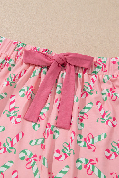 Roze kerstpyjamaset met knoop en zakmotief in zuurstokprint