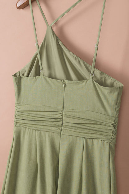 Groene asymmetrische jumpsuit met dunne bandjes, één schouder en wijde pijpen